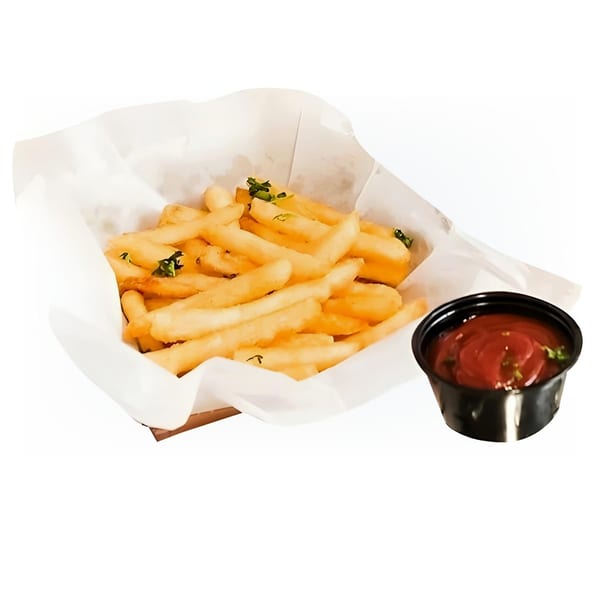 A basket of golden french fries with green herbs, next to a small cup of ketchup.